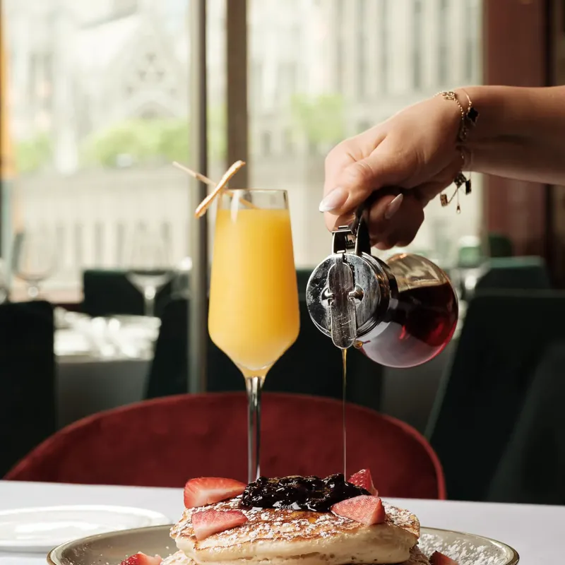 Pancakes with berries and a mimosa at breakfast